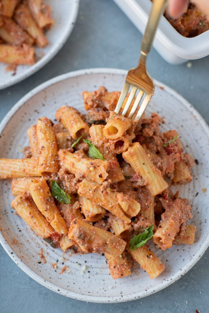 Overhead view of baked ziti with ground turkey on a small dinner plate.