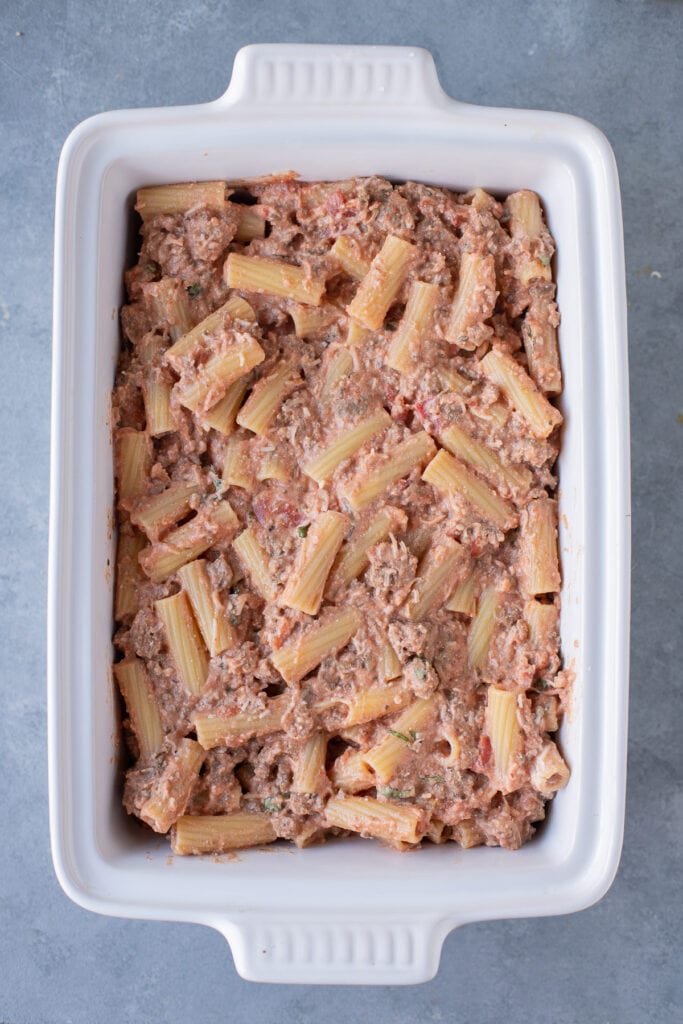 Uncooked pasta casserole in a white baking dish, viewed from overhead.
