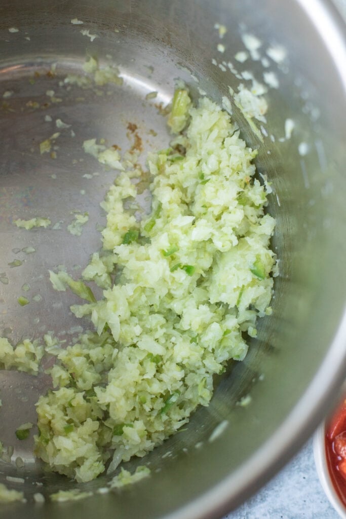 A close up of vegetables being sauted in a pot for chicken tortilla soup
