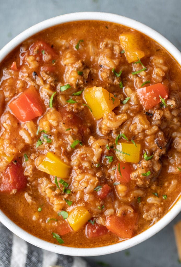 A close up bowl of stuffed pepper soup on a grey background