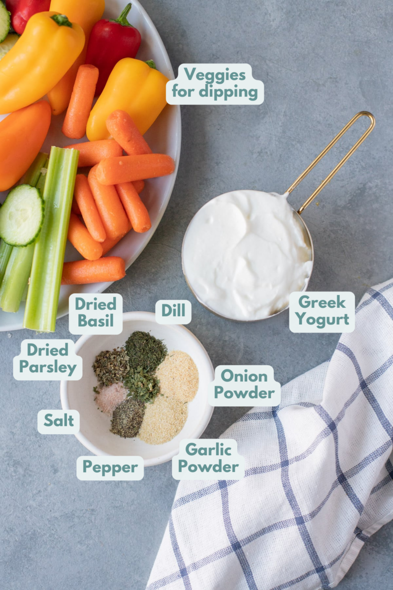 Greek yogurt dip ingredients in a white bowl and a measuring cup: greek yogurt, garlic powder, onion powder, dried dill, dried parsley, dried basil, salt & pepper