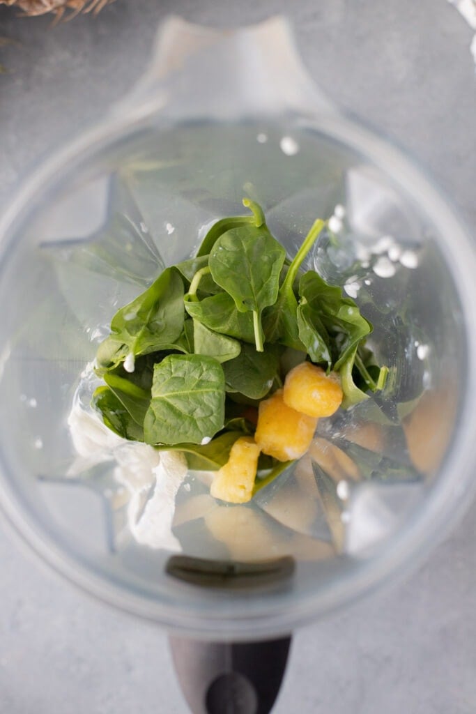 All ingredients (unblended) for green smoothie in a blender