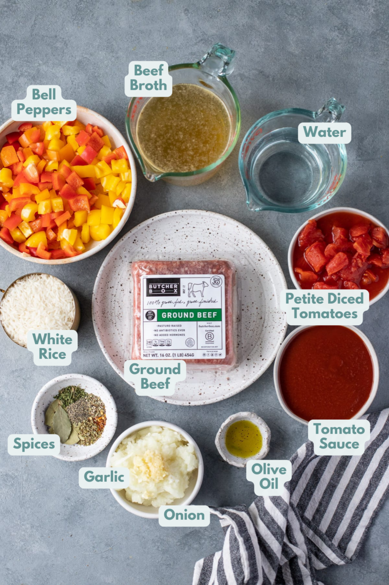 Ingredients for stuffed pepper soup in white and clear bowls on a grey background: ground beef, onion, garlic, red, orange, yellow or green bell peppers, petite diced tomatoes, tomato sauce, olive oil, water, beef broth, dried parsley, dried basil, dried oregano, pepper, bay leaf, red pepper flakes, white rice (optional) 