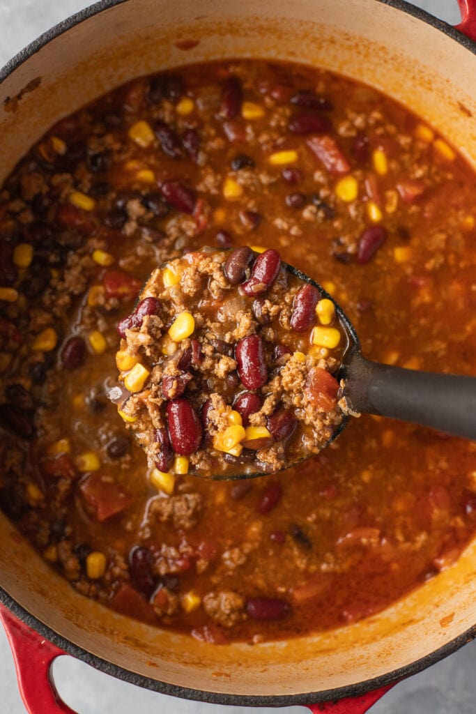 Taco soup in a stock pot with a ladle taking a big scoop out