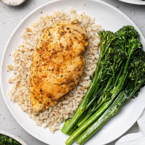 A close up of baked boneless chicken breast on a small white bowl