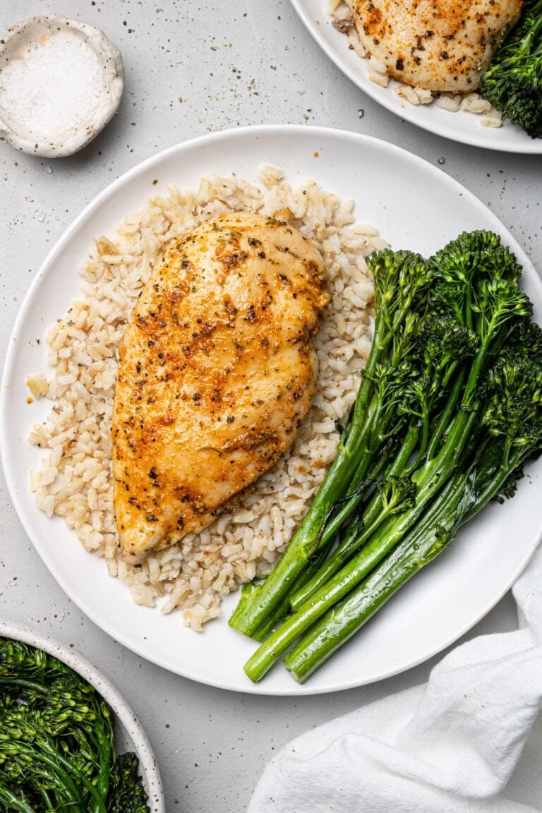 A close up of baked boneless chicken breast on a small white bowl