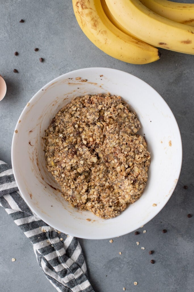 all ingredients for banana breakfast cookies in a white bowl mixed together