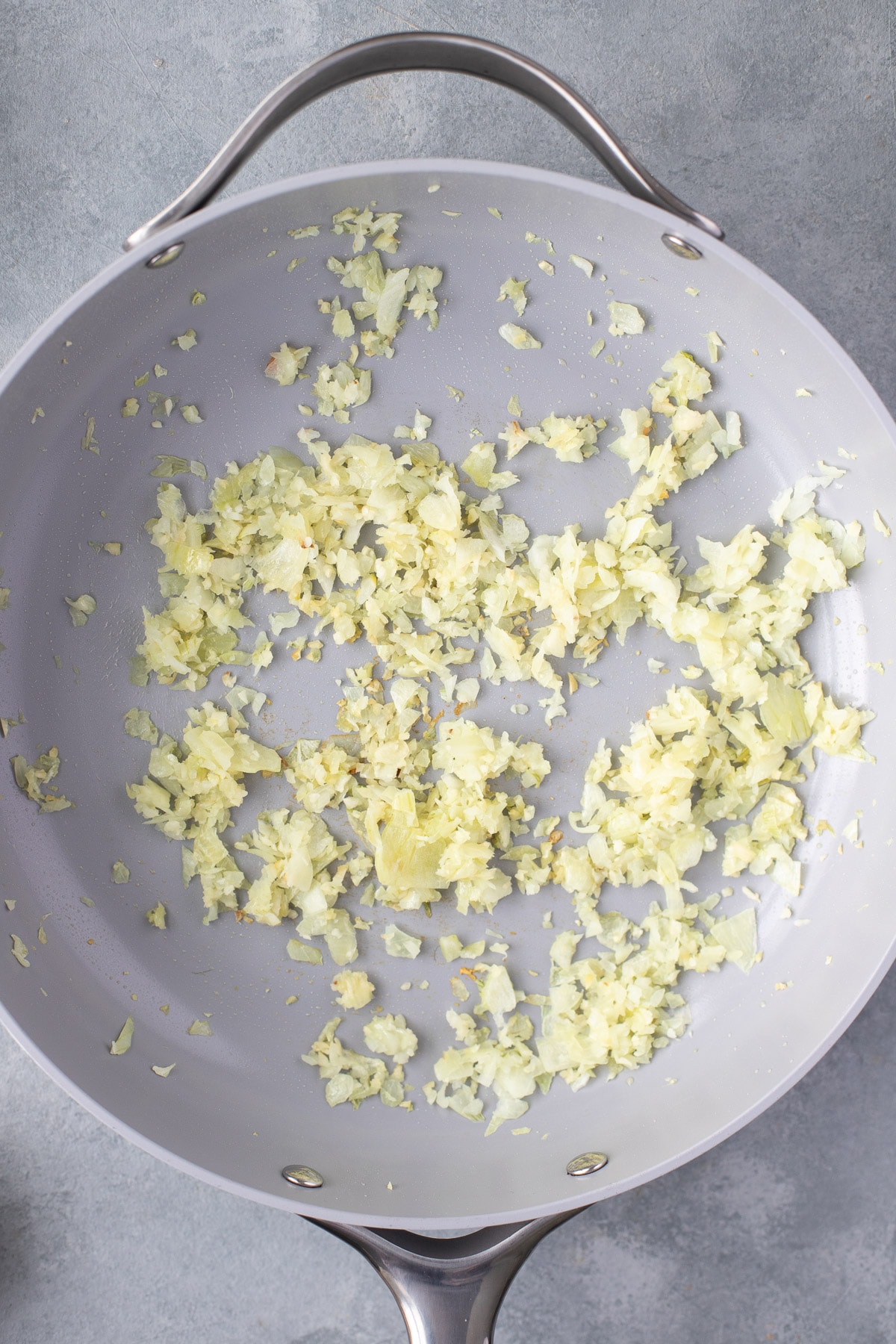 Sautéd olive oil, onions and garlic in a pan for cauliflower fried rice