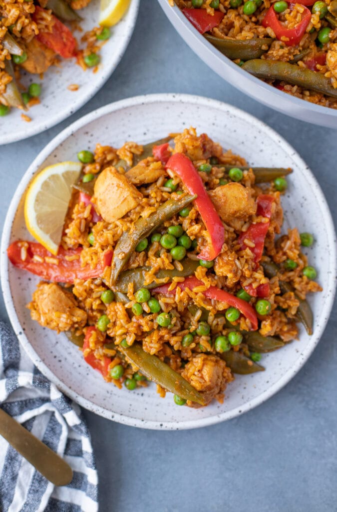 chicken paella on a white plate on a grey background