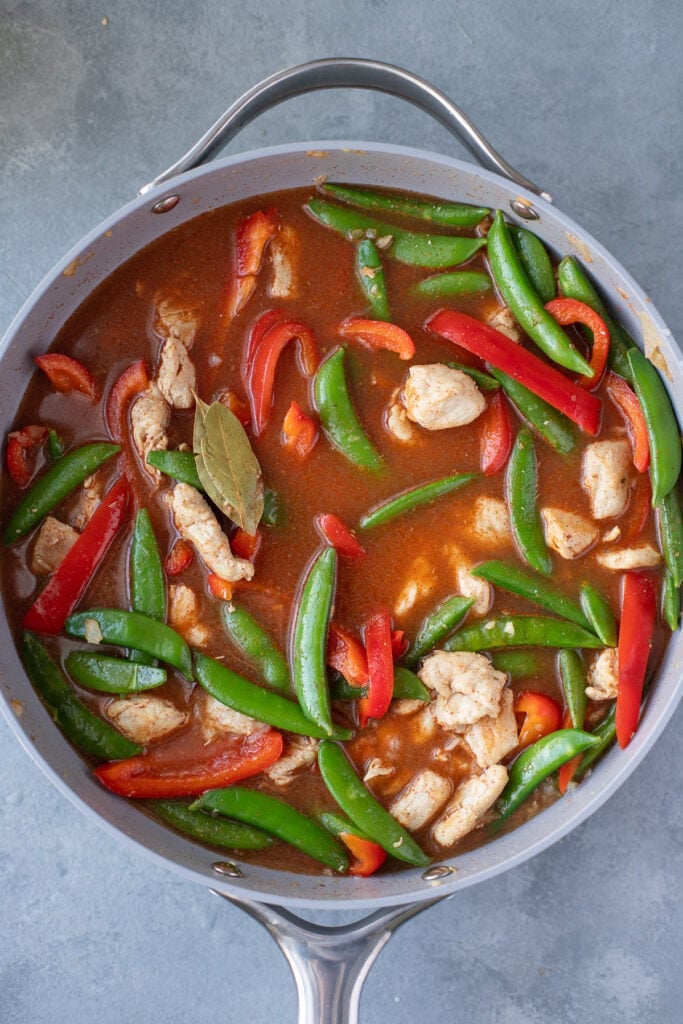 chicken paella in a pan, stirred, but uncooked