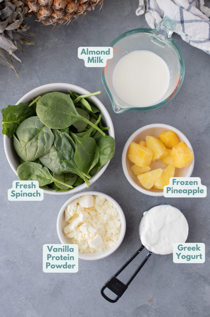 Ingredients for a green smoothie in whole bowls: fresh spinach, almond milk, frozen pineapple or mango, vanilla protein powder, nonfat greek yogurt.