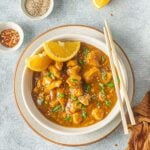 A close up of instant pot chicken in a white bowl on a grey background