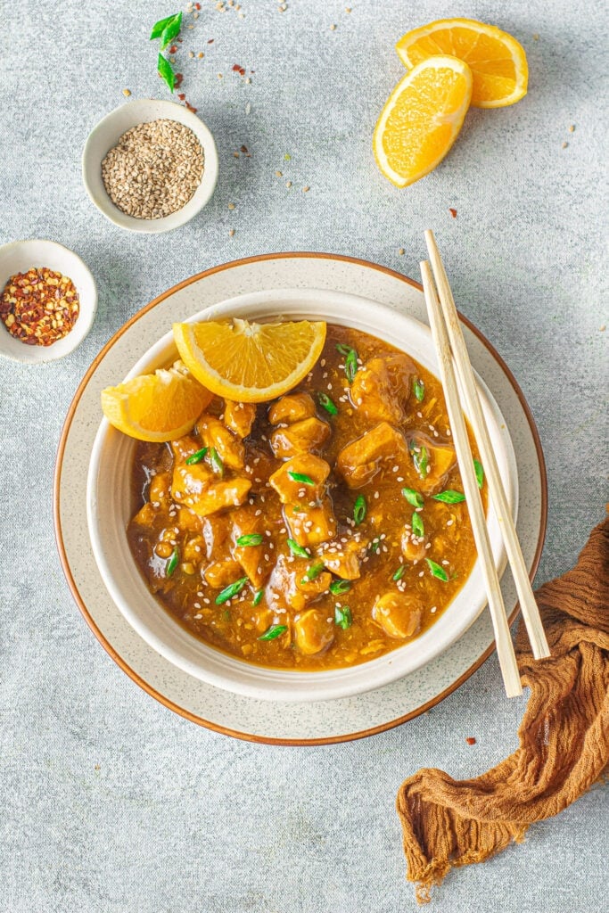 A close up of instant pot chicken in a white bowl on a grey background