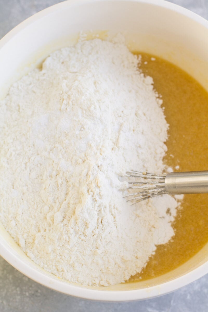 A whisk mixing dry ingredients into wet for pizzelle cookies.