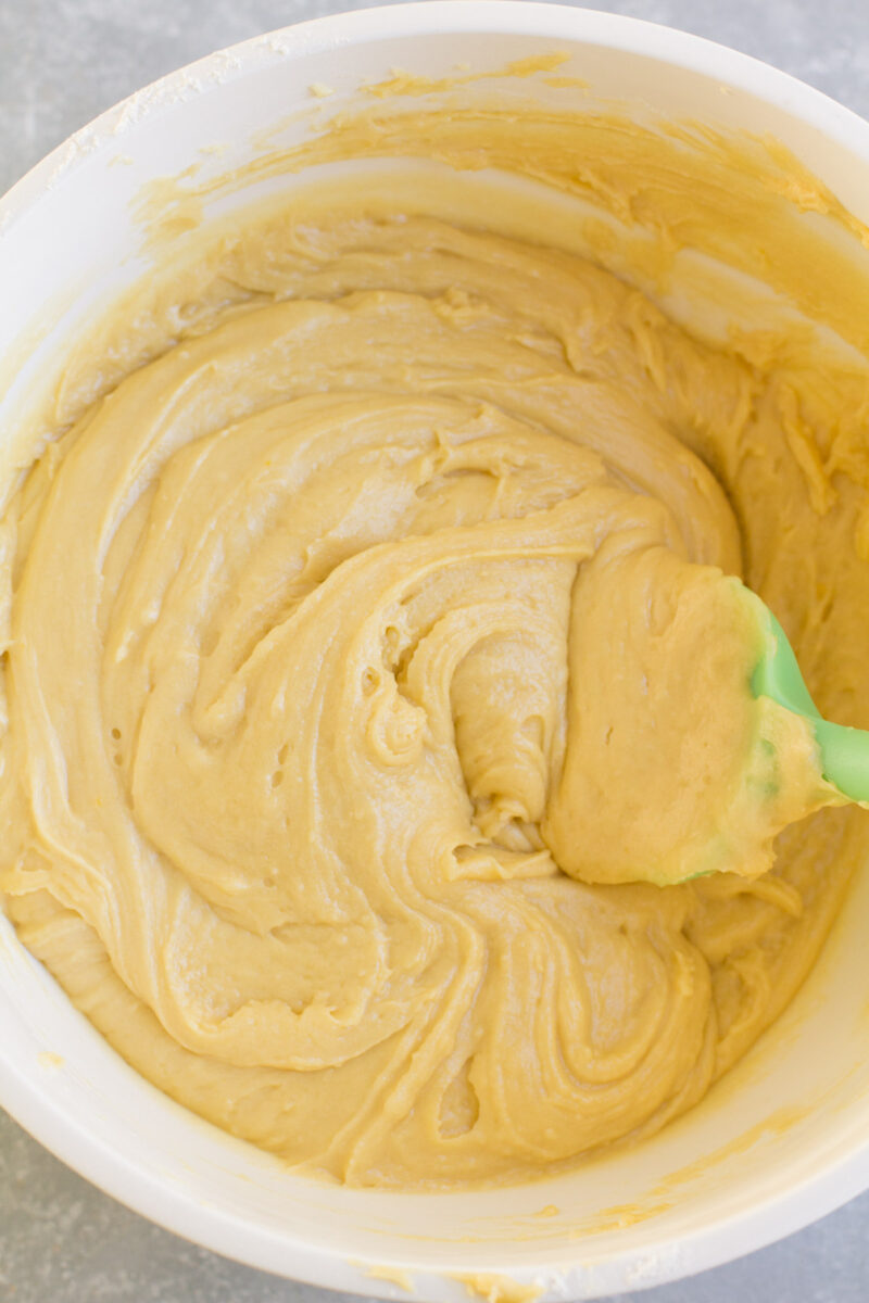 Pizzelle cookie dough in a bowl being mixed with a spatula.