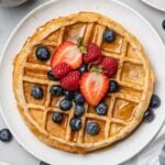 an overhead shot of healthy protein waffles with strawberries and blueberries on top