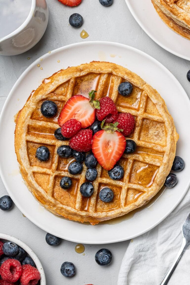 an overhead shot of healthy protein waffles with strawberries and blueberries on top