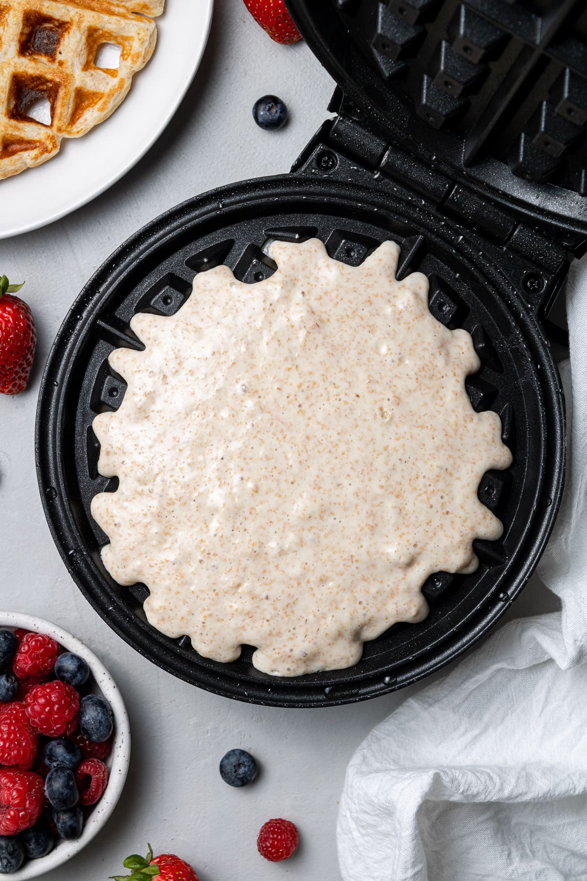 Batter for healthy protein waffles in a waffle iron uncooked