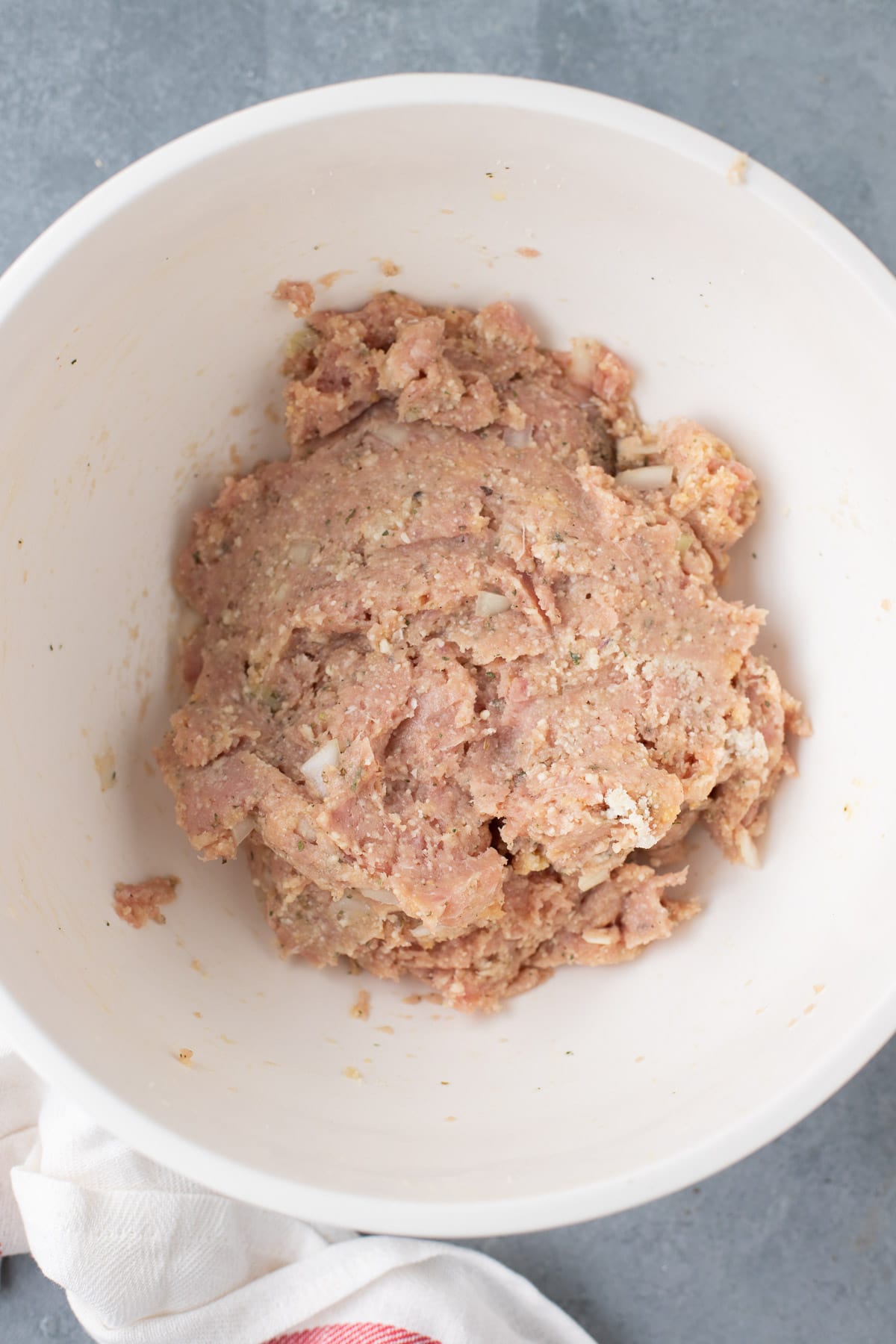 Italian turkey meatballs mixture in a white bowl, viewed from overhead.