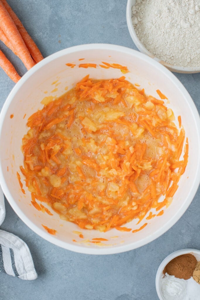 All wet ingredients for pineapple carrot muffins mixed together in a white bowl