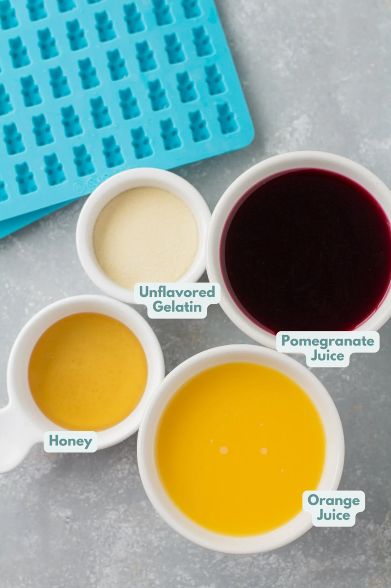 Ingredients for healthy gummy bears in small bowls laid out on a grey background