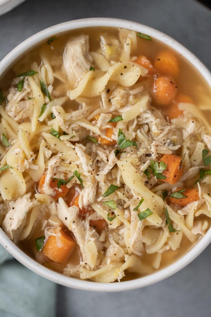 A close up of chicken noodle soup in a bowl