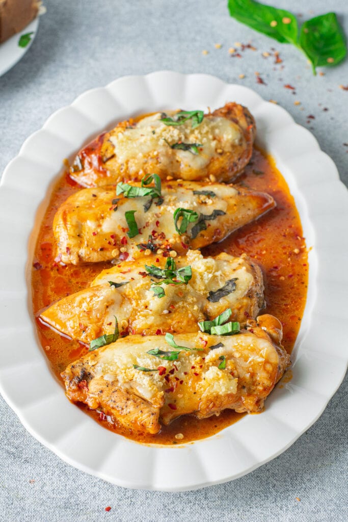 Instant pot chicken parmesan on a white platter on a grey background