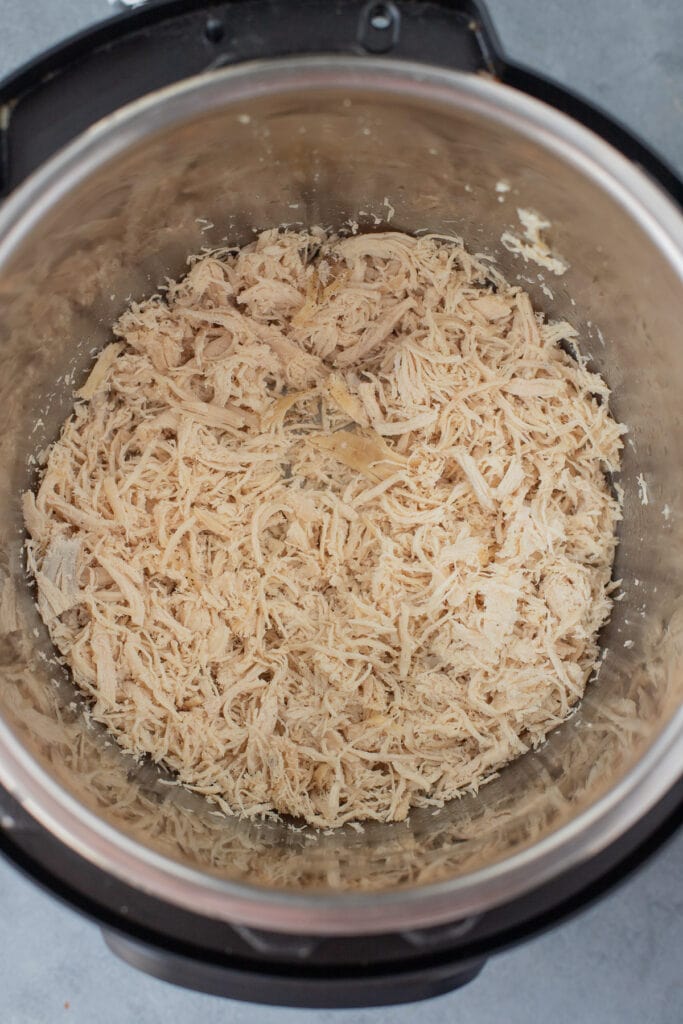 an overhead shot of instant pot shredded chicken in a pressure cooker