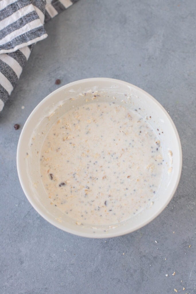 peanut butter overnight oats mixed in a large white bowl on a grey background to be refrigerated overnight