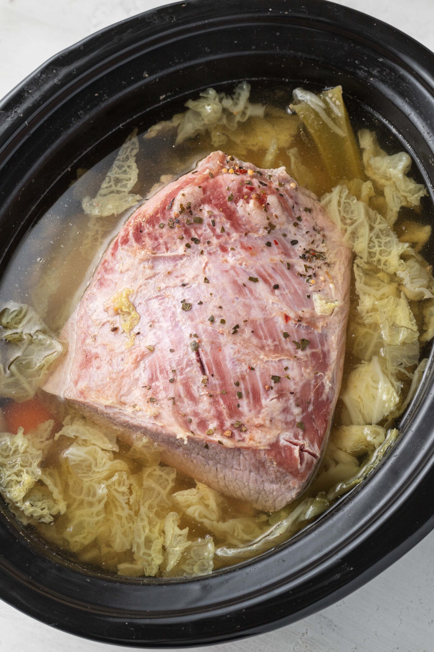 corned beef, cabbage, carrots, potatoes in a slow cooker fully cooked
