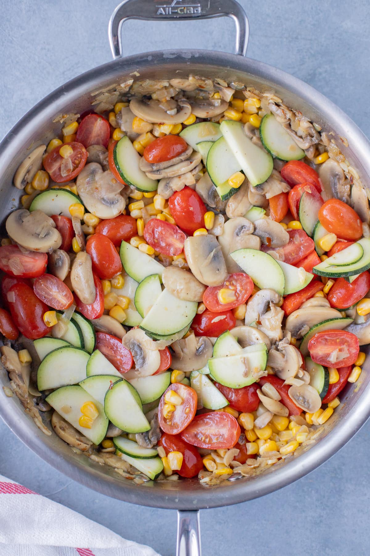 Sautéed veggies in a pan for pasta primavera on a grey background
