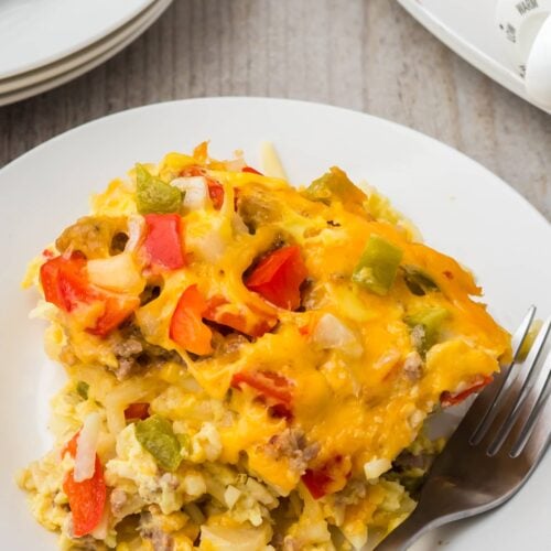 A piece of crock pot breakfast casserole on a white plate with a fork on the side