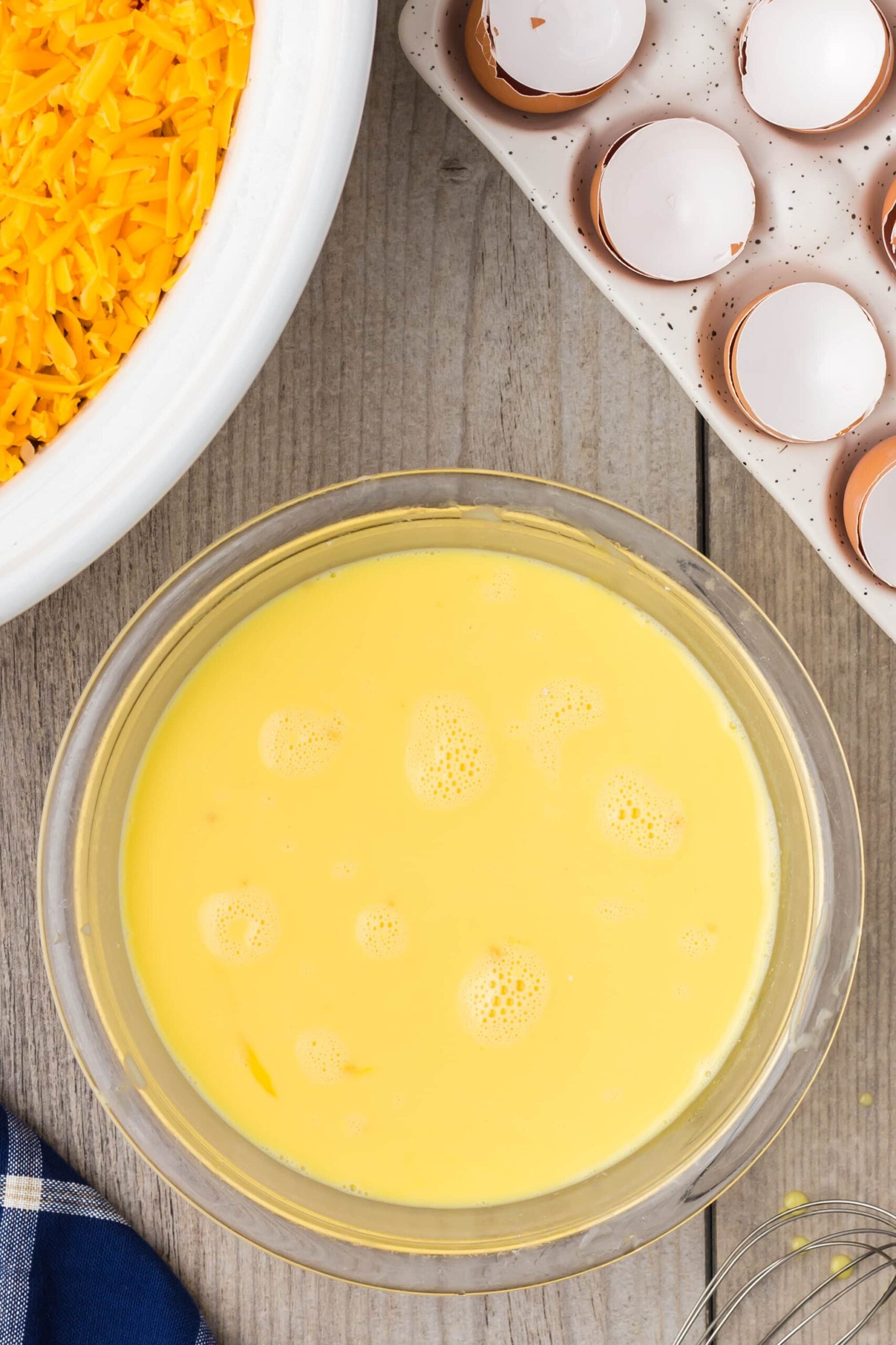 eggs, milk, garlic, and dry mustard whisked together in a bowl for crock pot breakfast casserole