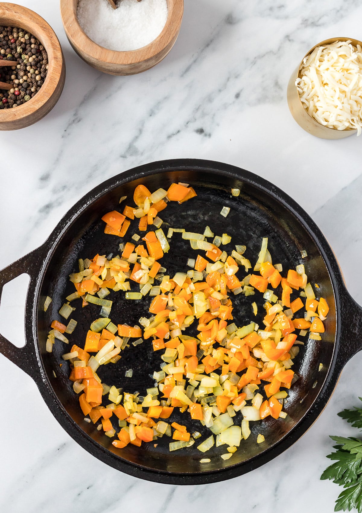 diced peppers, onions in a cast iron pan after being softened for a vegetable frittata
