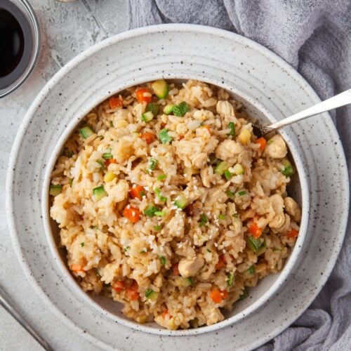 An overhead shot of a bowl of instant pot fried rice with a small bowl of sesame seeds and soy sauce on the side