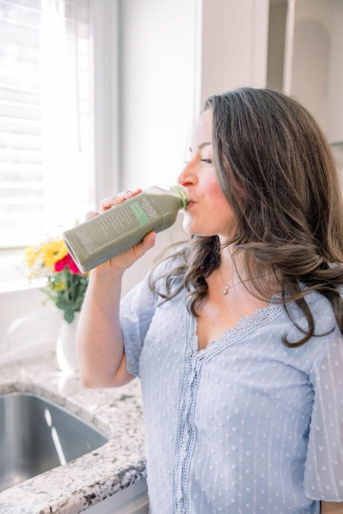 a girl drinking out of a splendid spoon smoothie
