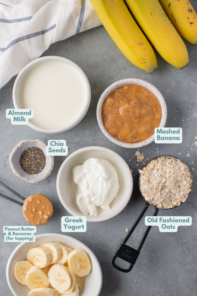 Ingredients for banana overnight oats in white bowls: old fashioned oats, nonfat greek yogurt, almond milk, banana, chia seeds (optional)