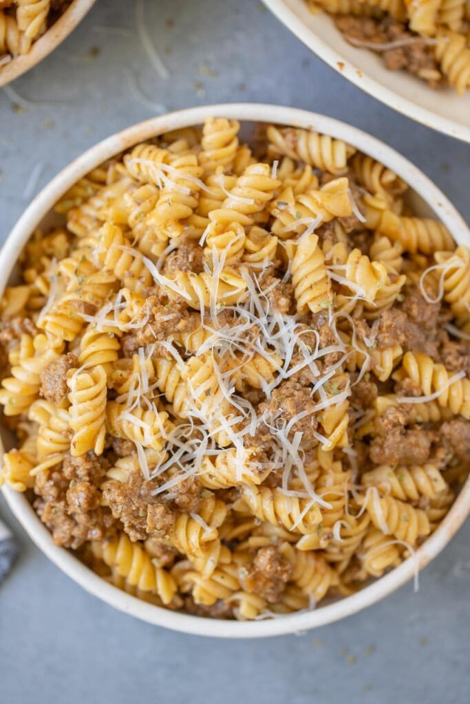 A bowl of homemade hamburger helper on a grey background