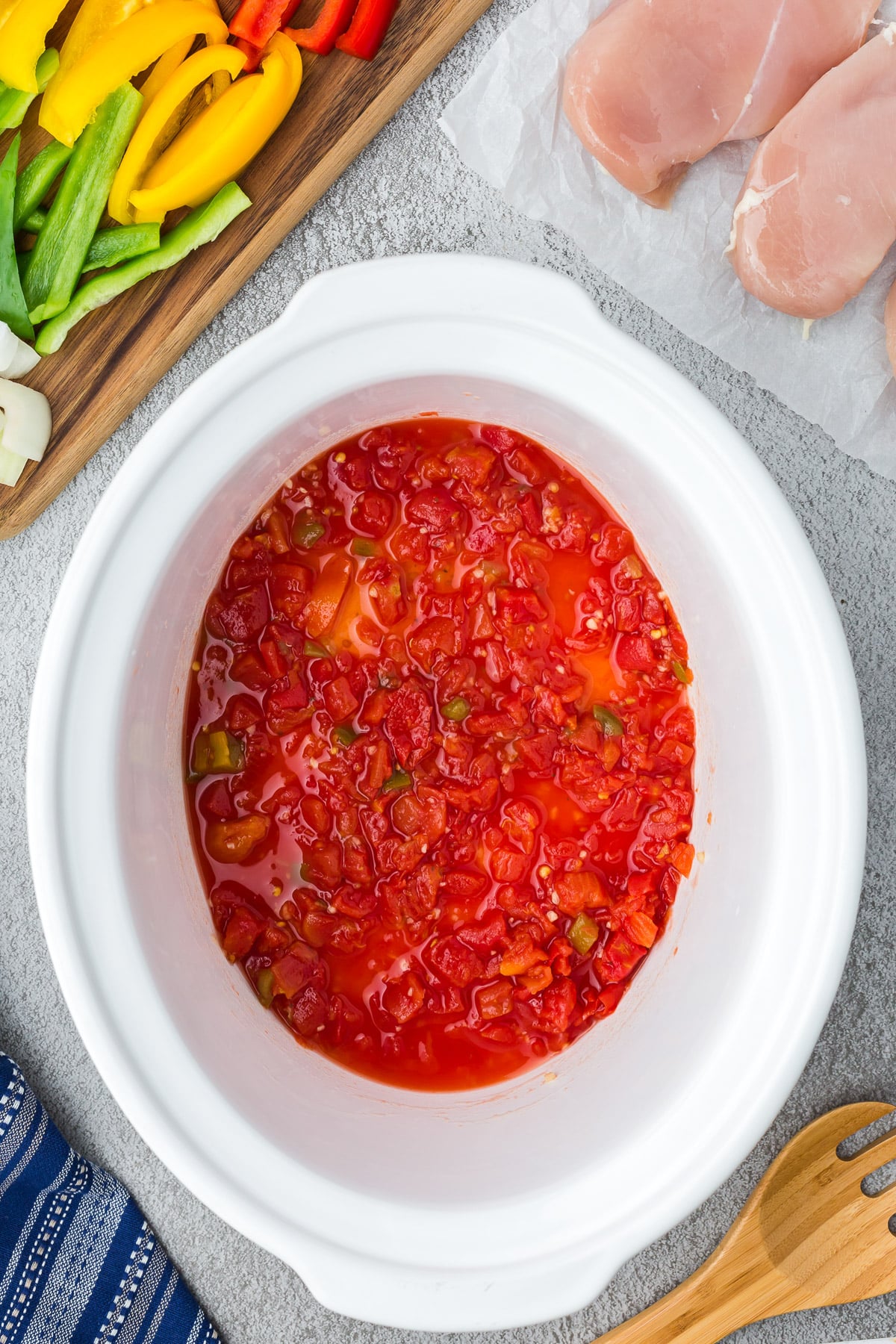 Onion, Rotel, Garlic mixture in a crock pot for slow cooker chicken fajitas