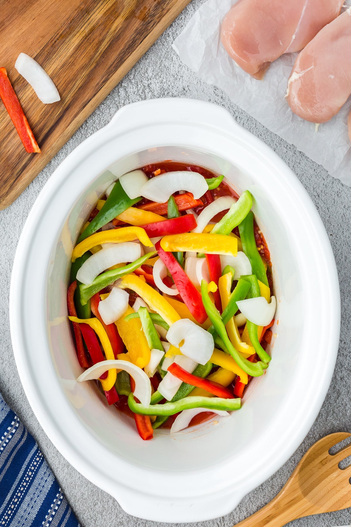 Peppers and onions on top of rotel mixture for crockpot chicken fajitas