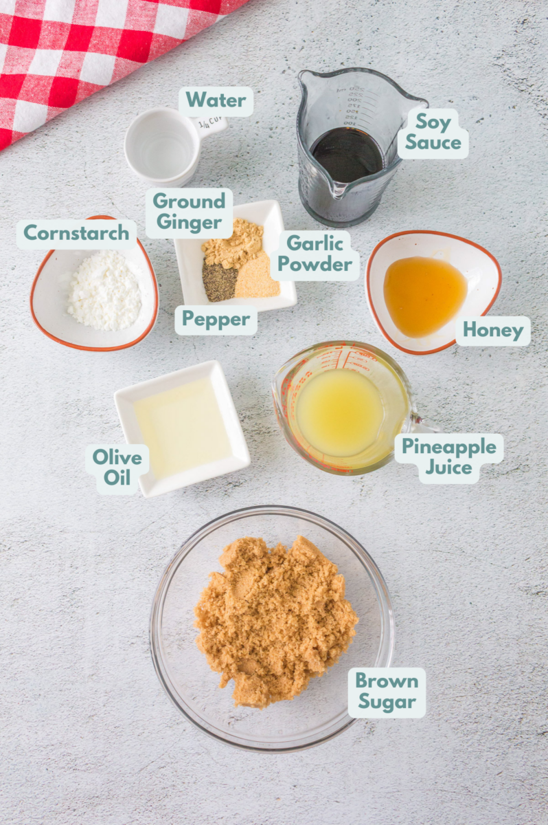 Ingredients for teriyaki chicken and homemade teriyaki sauce in white bowls: chicken, soy sauce, brown sugar, honey, pepper, ground ginger, garlic powder, olive oil, pineapple juice, water, cornstarch