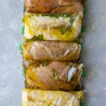 5 Healthy Chicken Marinades in individual ziploc bags on a grey background