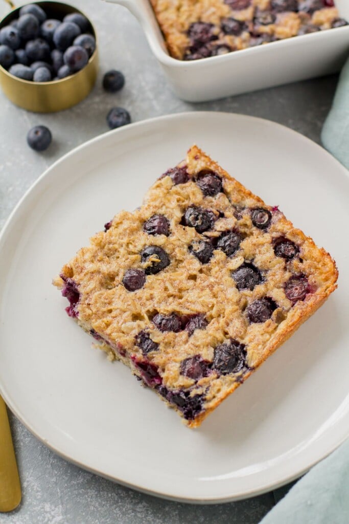 A slice of blueberry baked oatmeal on a white dish