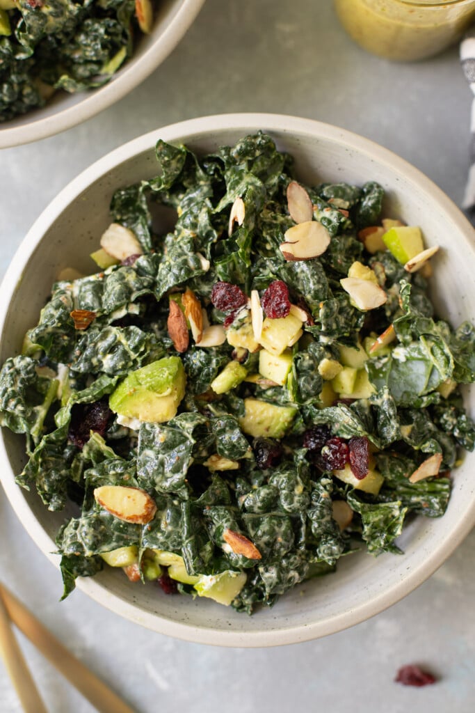 Easy kale salad in a grey bowl on a grey background - a healthy dinner everyone will love