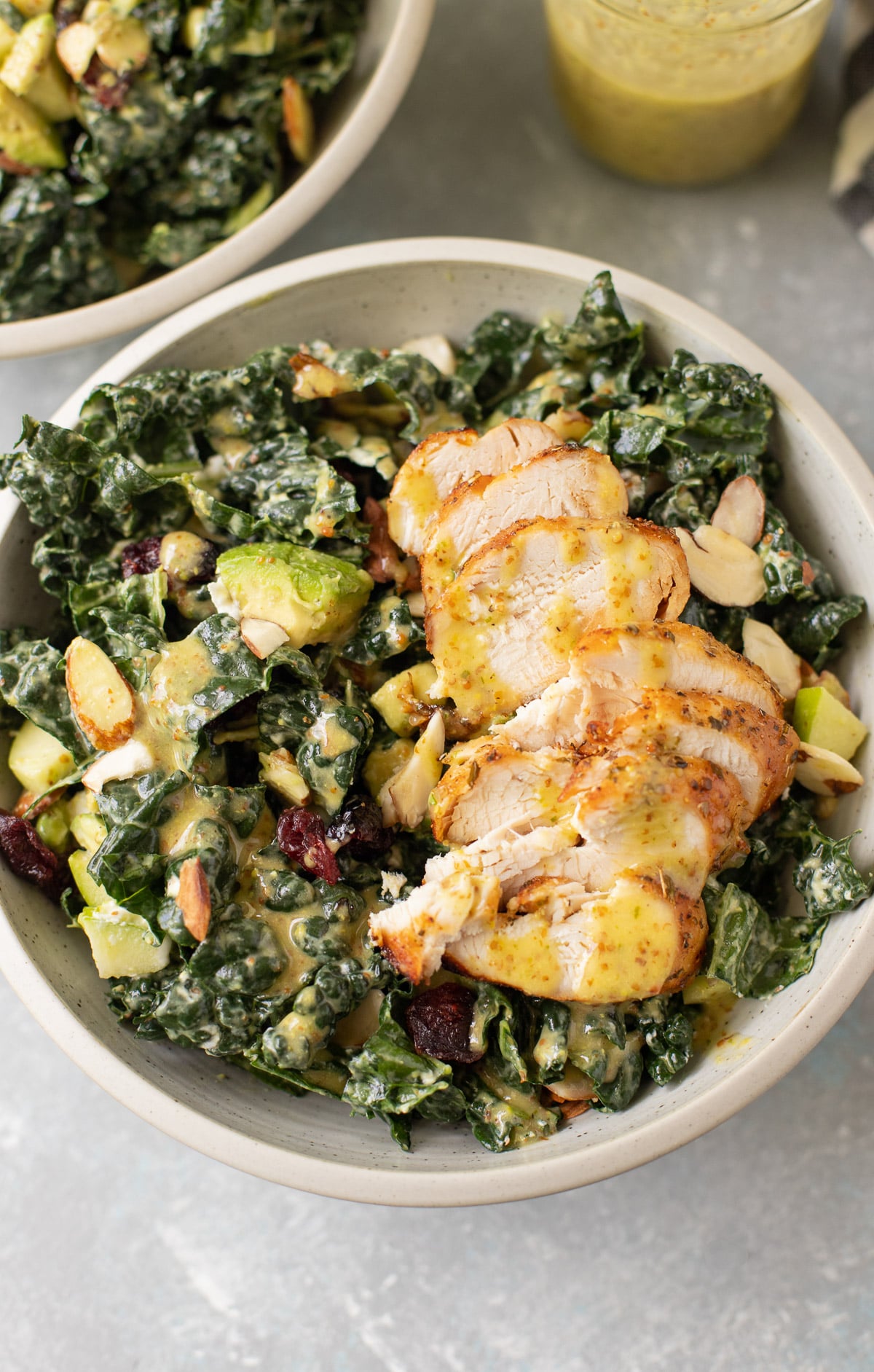 Lemon vinaigrette drizzled over a kale salad with grilled chicken.