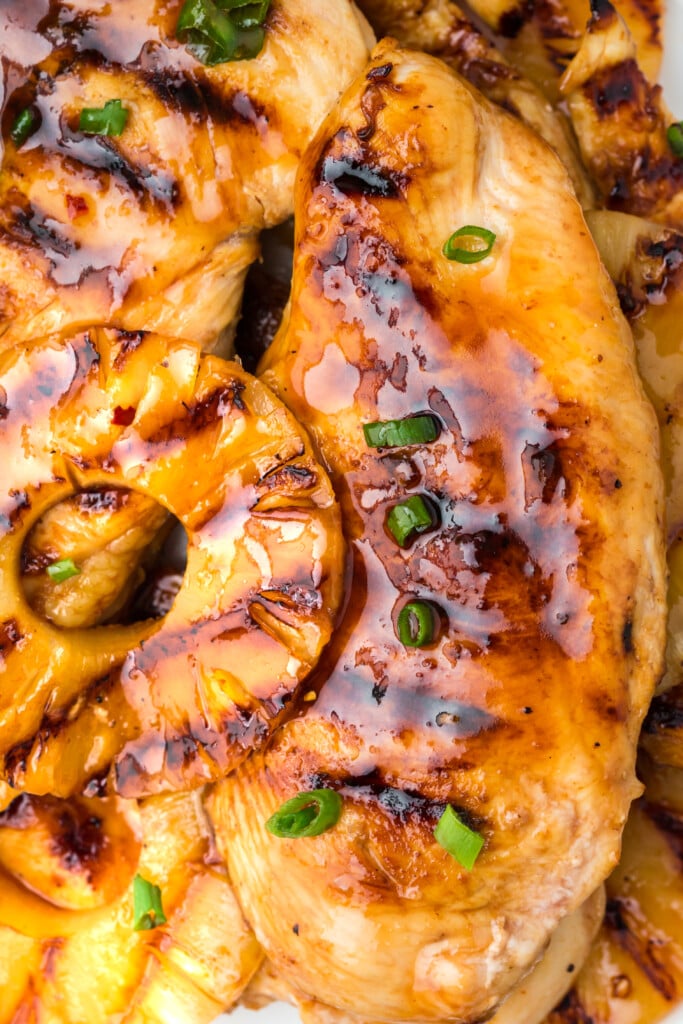 A close up of pineapple grilled chicken with green onions on top