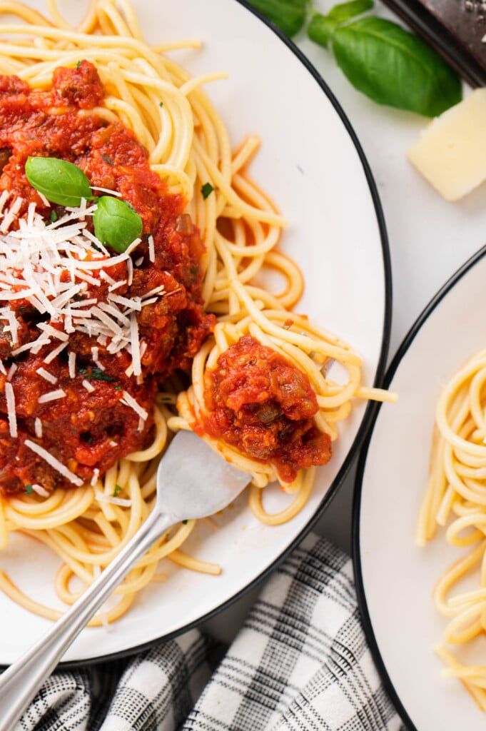 a plate of pasta with healthy turkey bolognese with a fork taking a bite out of it