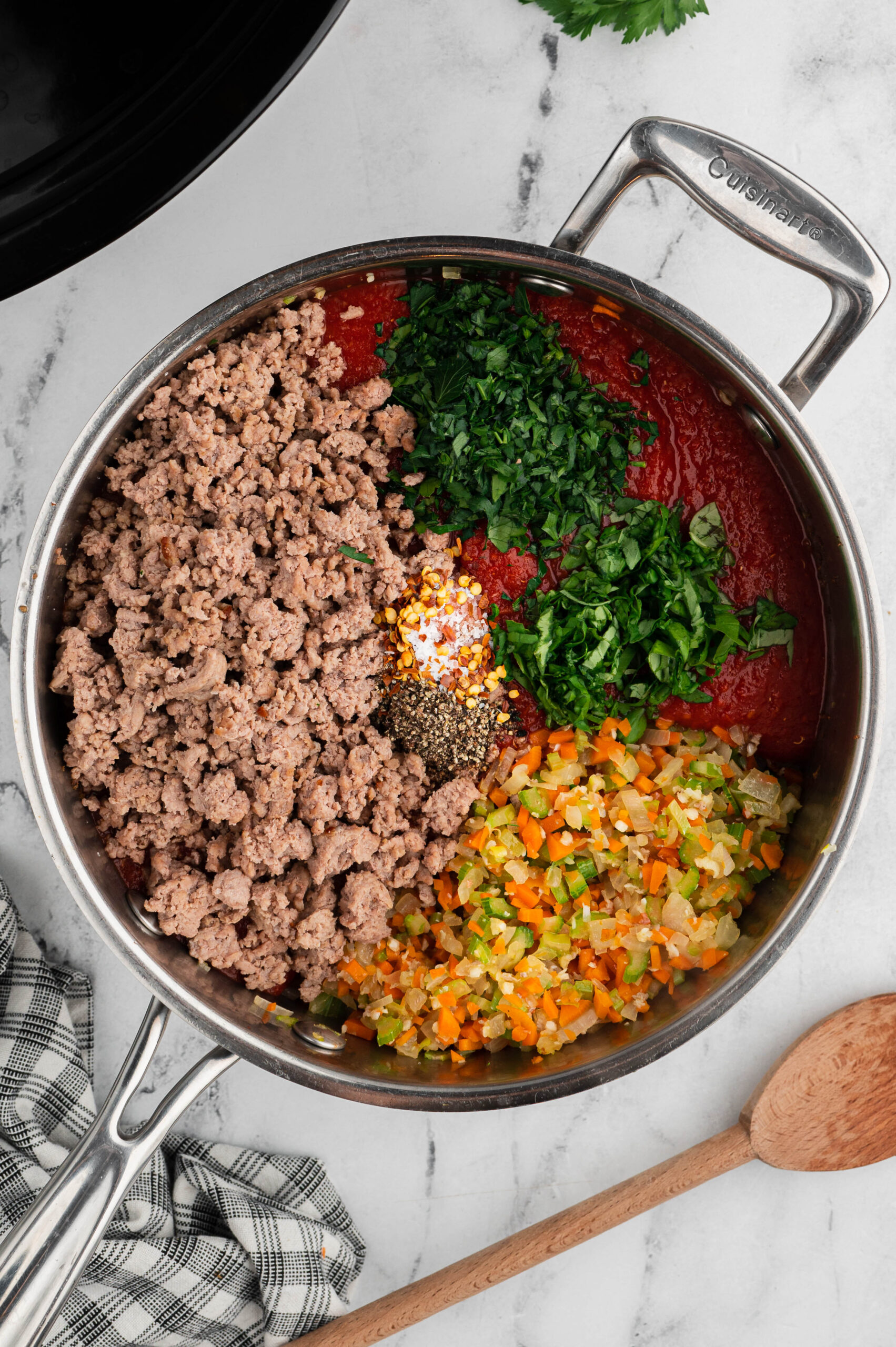 Overhead view of turkey Bolognese ingredients in a skillet before being stirred together.
