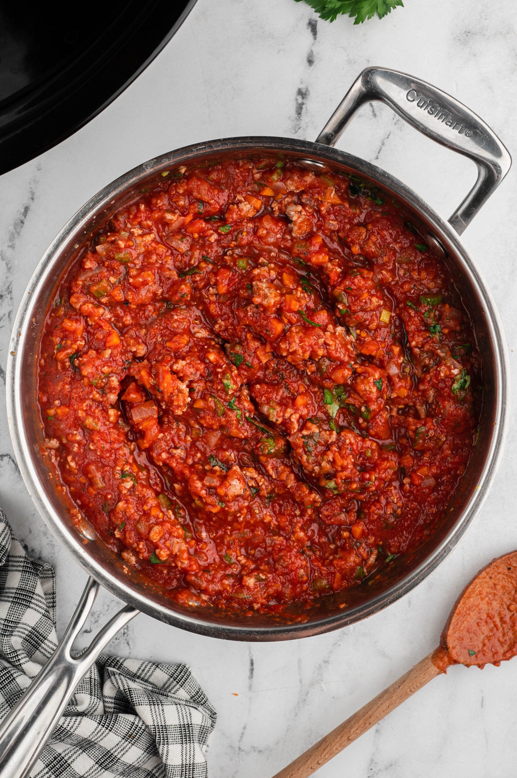 Overhead view of chunky meat sauce in a stainless steel skillet.