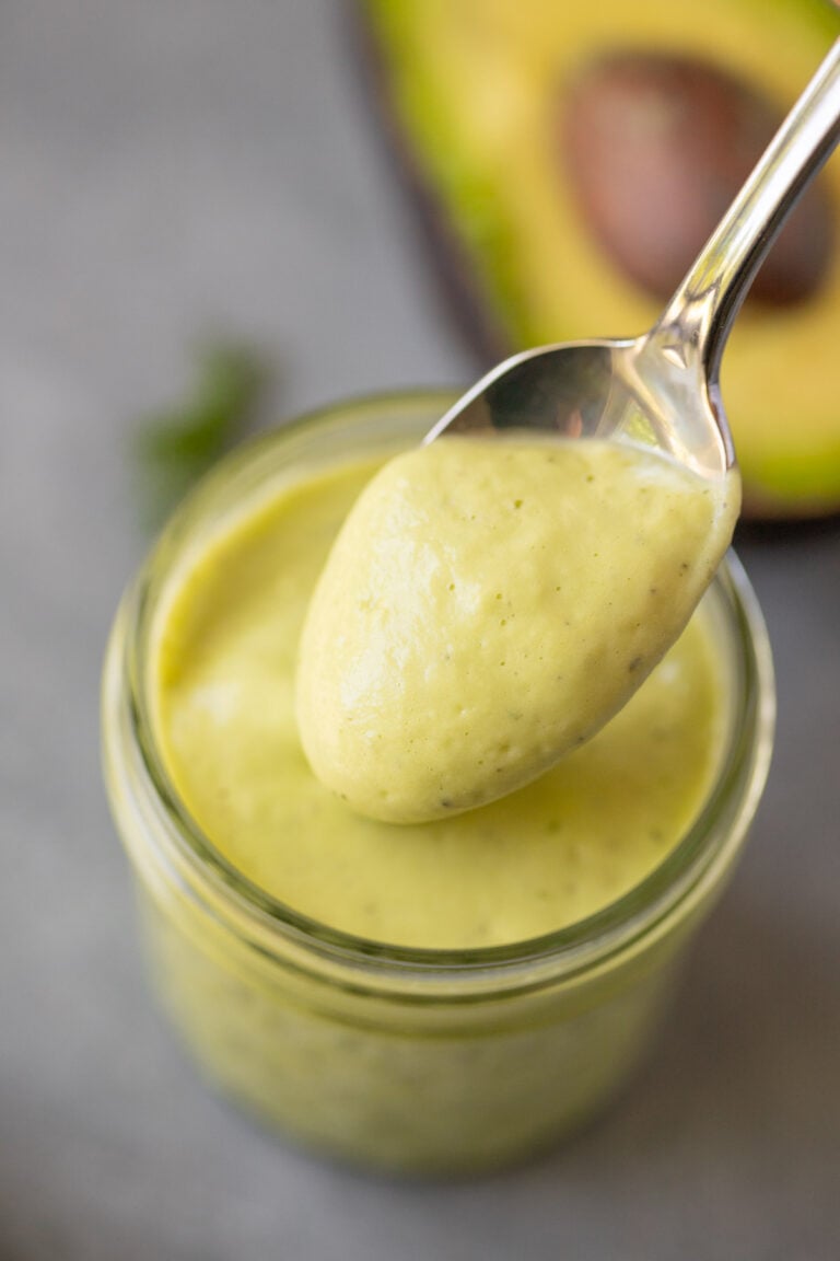 a close up of avocado ranch dressing in a mason jar